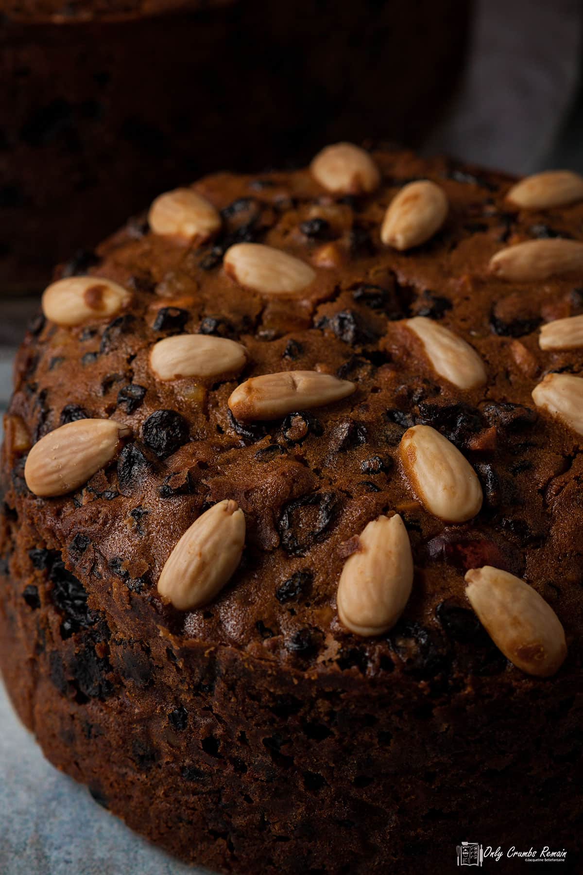 rich fruit cake with blanched almonds on top.