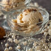 two glass dishes with scoops of Christmas pudding and brandy sauce ice cream