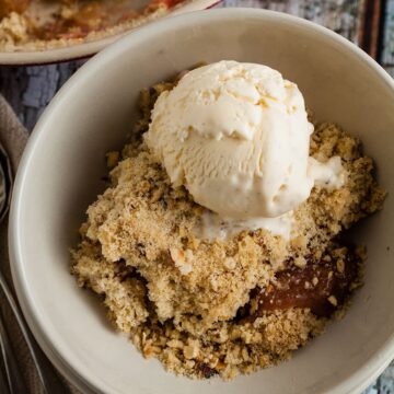 bowl of rhubarb and ginger crumble with vanilla ice cream.