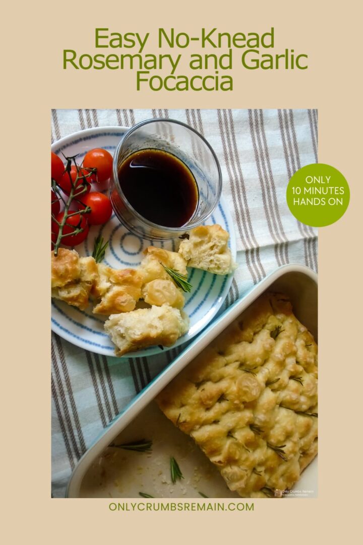 rosemary and garlic focaccia in baking dish with pieces cut into square and on a side plate with tomatoes and a dish of balsamic vinegar.