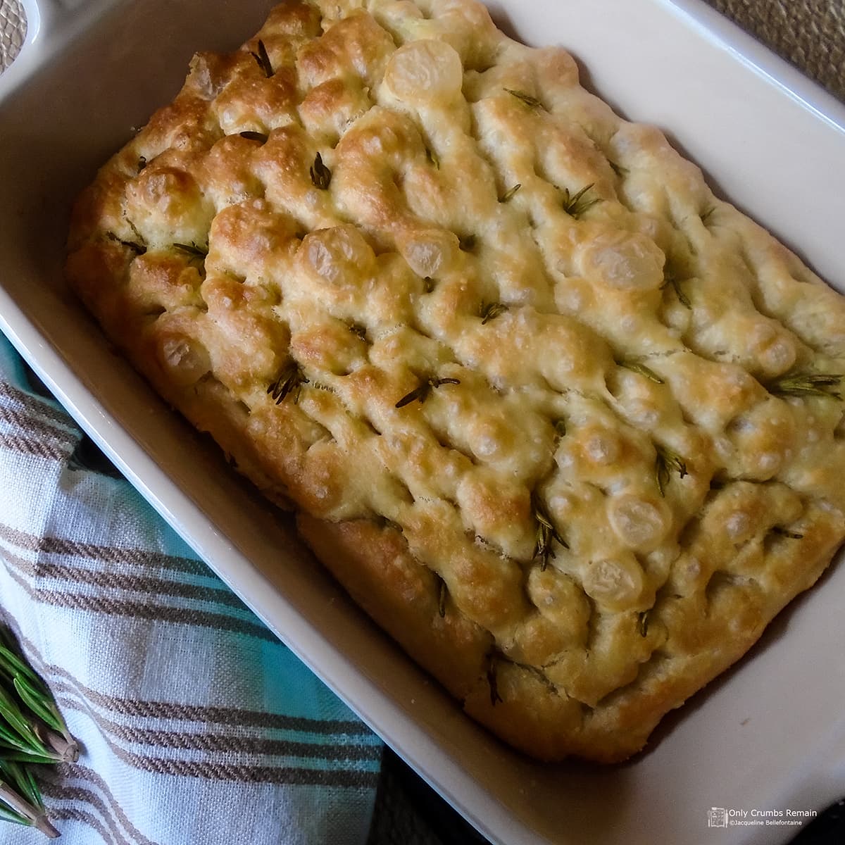 Baked Rosemary and garlic focaccia in baking dish.