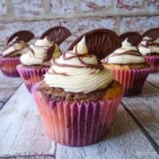 Marbled chocolate orange cup cakes decoarted with buttercream chcolate drizzle and a chocolate orange segment.