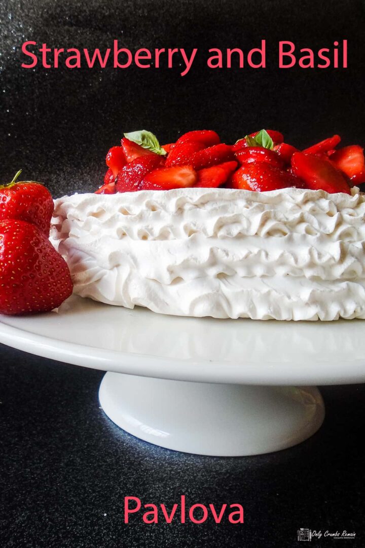 strawberry and basil pavlova on a cake stand.