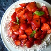 strawberry and basil pavlova on white plate.