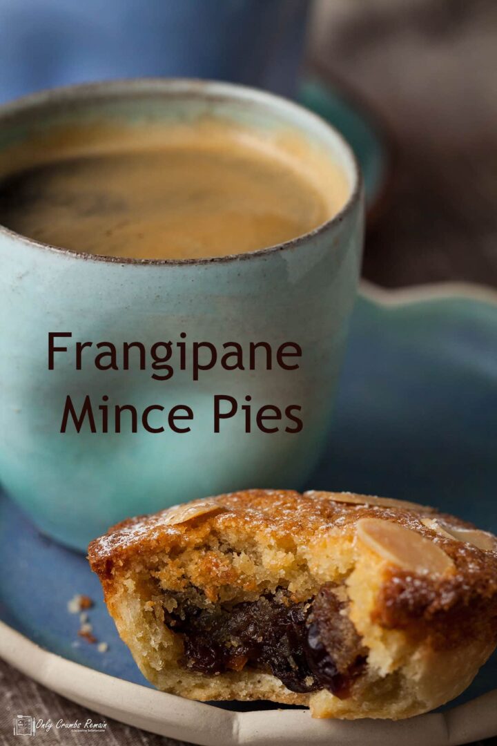 frangipane mince pie witgh bite removed next to coffee cup.