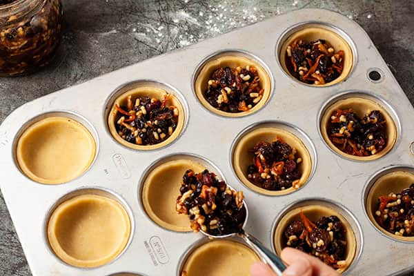 filling pastry cases with mincemeat.