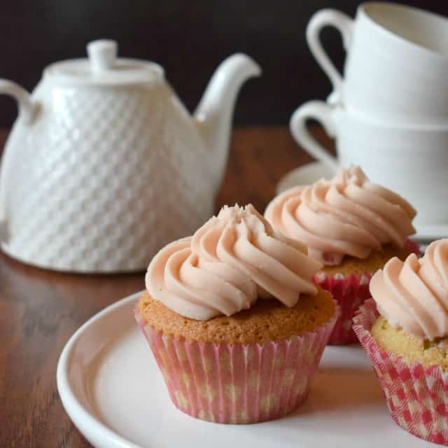 cherry and almond cupcakes with tea set behind