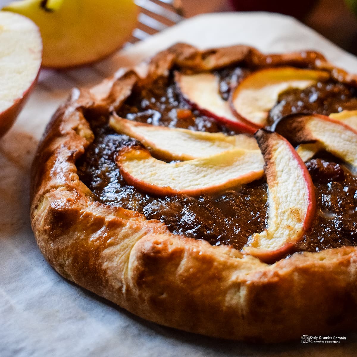 close up of mincemeat and apple galette on greaseproof paper placed on a cooling rack.