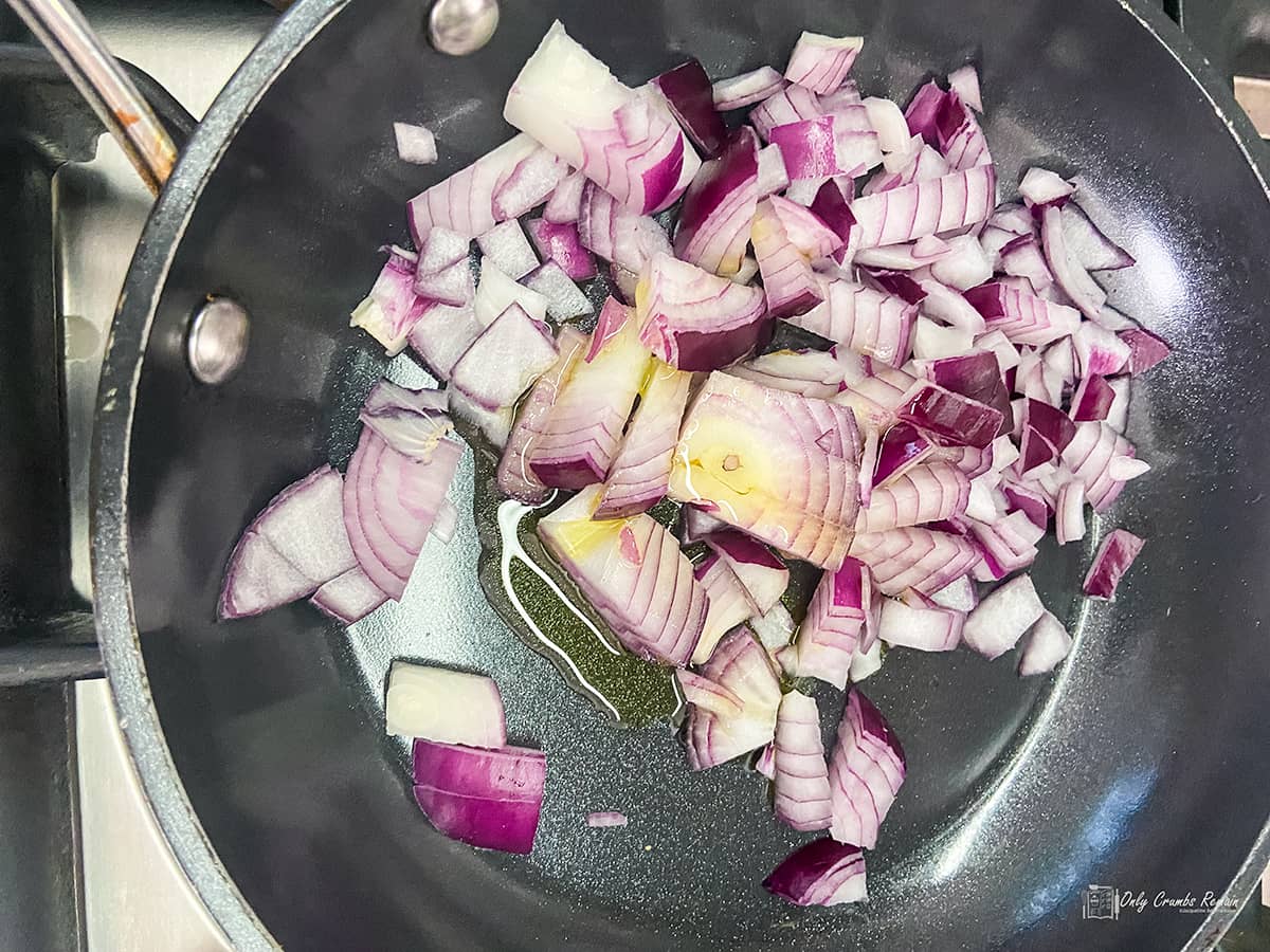 uncooked onions and oil in frying pan.