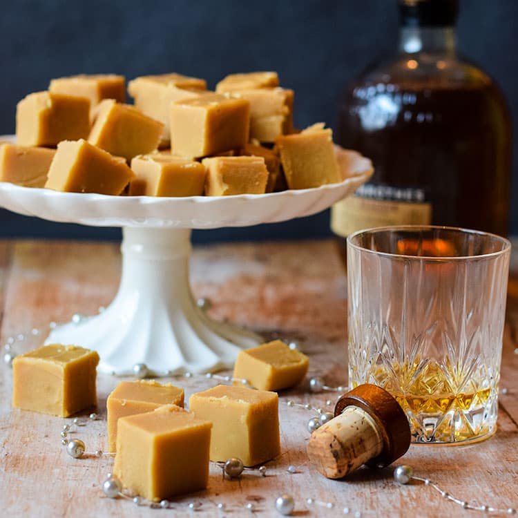 whisky fudge on a cake stand with whiskey glass.