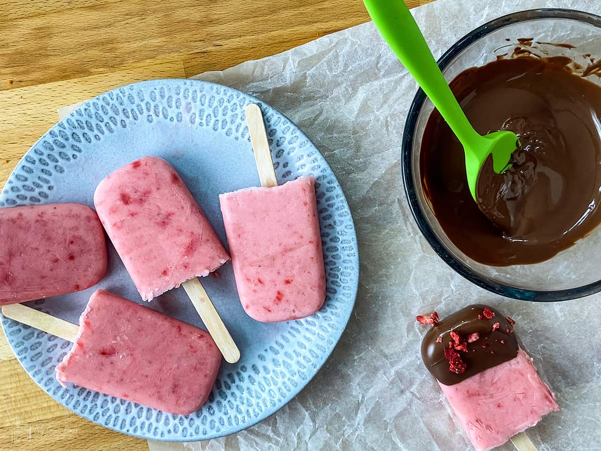 4 plain lollies and one dip in chocolate with bowl of melted chocolate on the side.