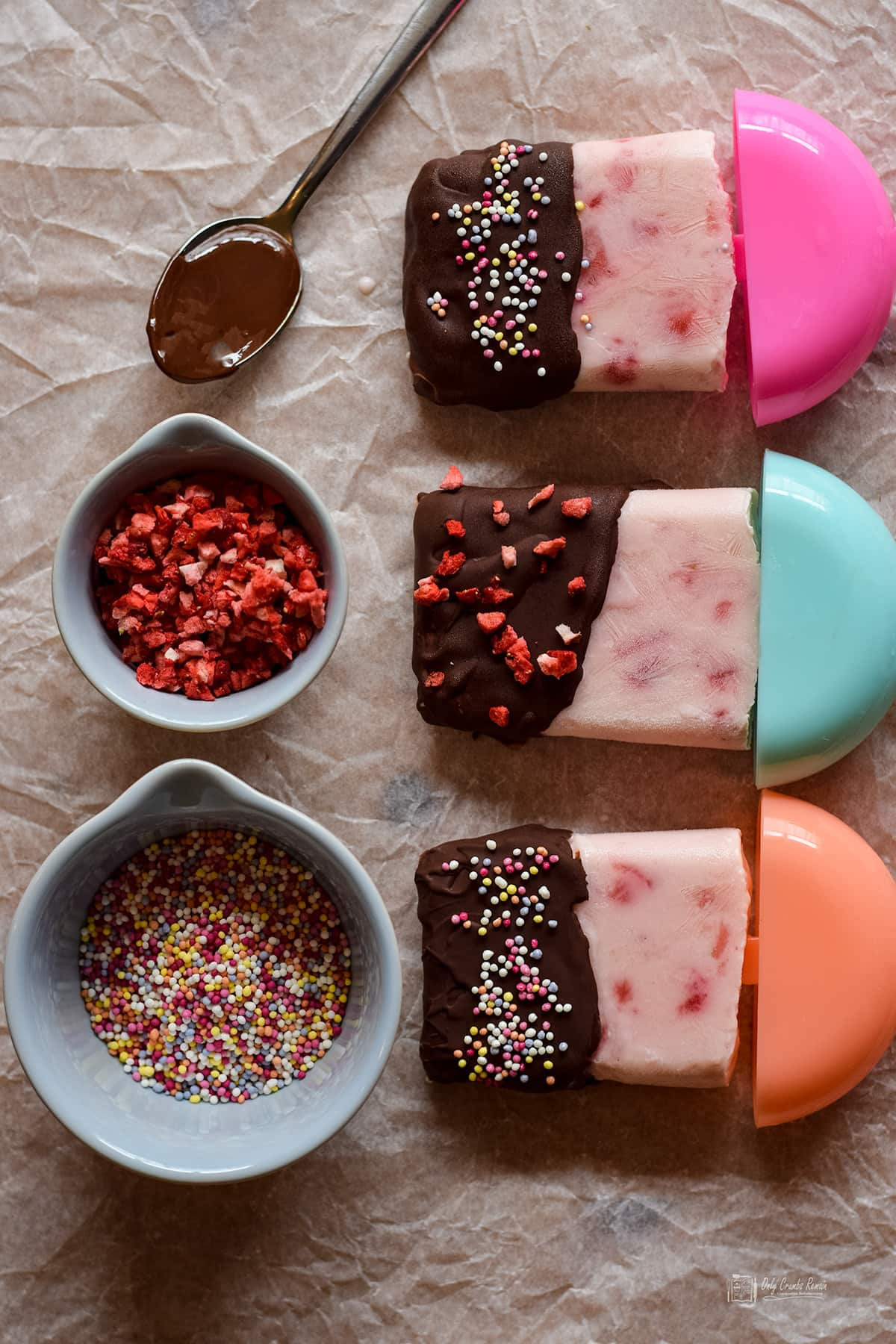 strawberry frozen yogurt lollies with different sprinkles.