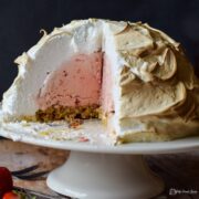 strawberry baked alaska cut open and portion removed to show inside.