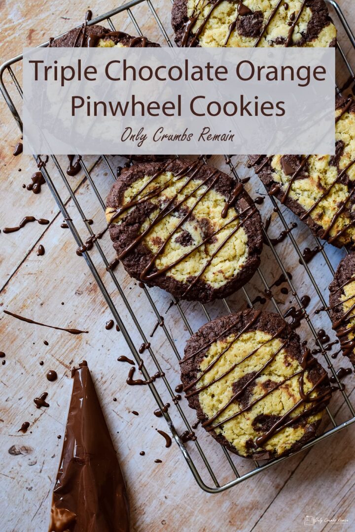 triple chocolate orange swirl cookies on a cooling rack with piping bag of chocolate on the side.