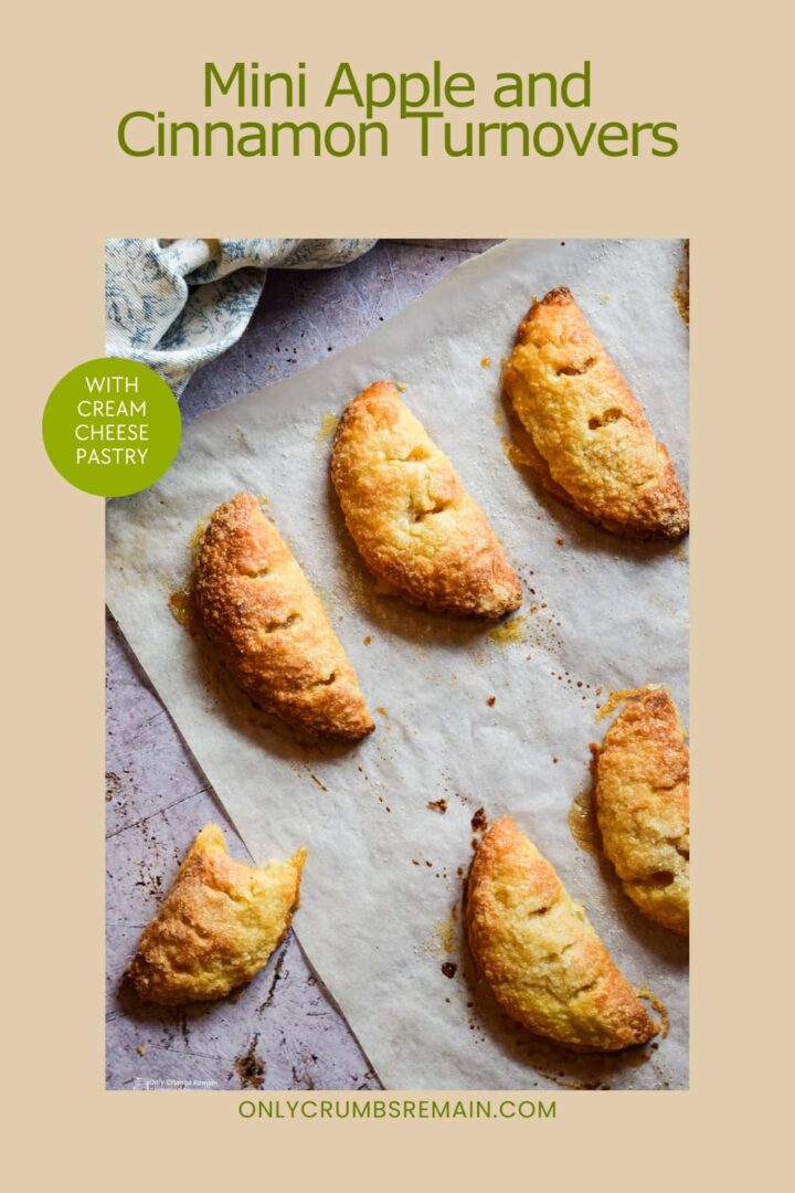 mini apple and cinnamon turnovers on baking parchment, one with bite removed. Text overlay for pinterest.