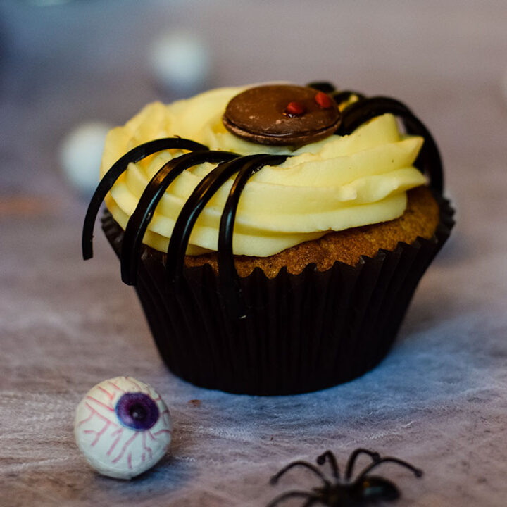 a blackcurrant and liquorice spider cupcakes with fake eyeball in front.