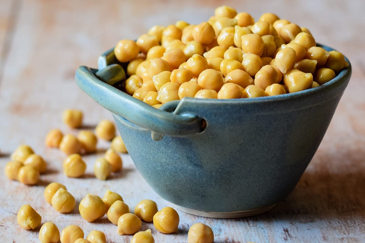 bowl of chick peas with some spilling over.