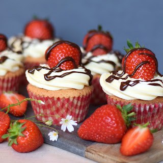4 strawberry cupcakes on a board