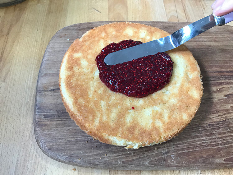 spreading jam on cake