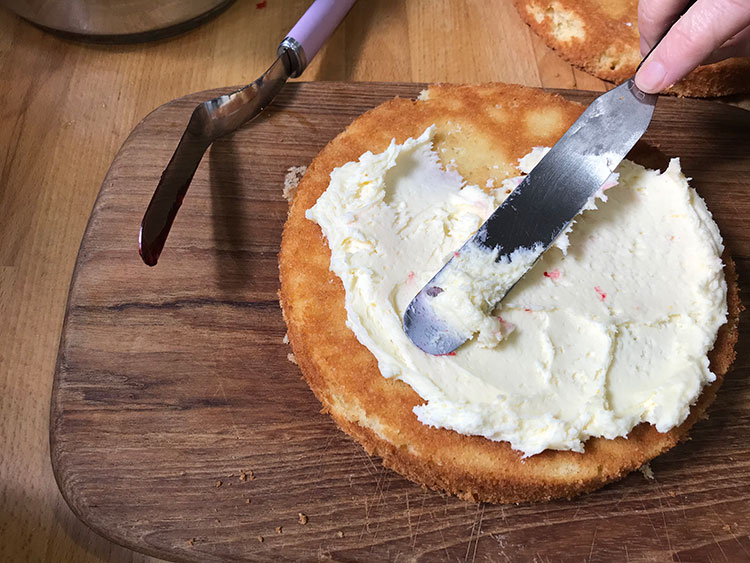 spreading butter cream on cake