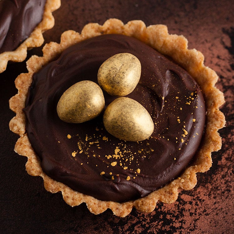 chocolate and salted caramel tart decorated with golden eggs