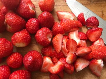 prepared strawberries on wooden board.