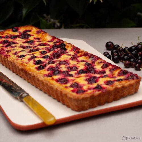blackcurrant and vanilla cream tart on serving platter.