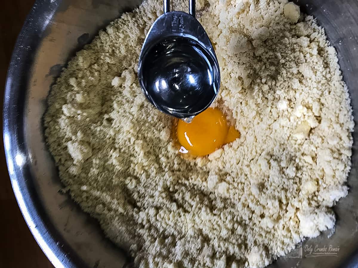 adding water and egg yolk to flour mixture
