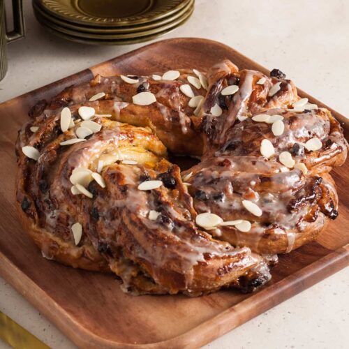 cranberry and pecan couronne on wooden plate.