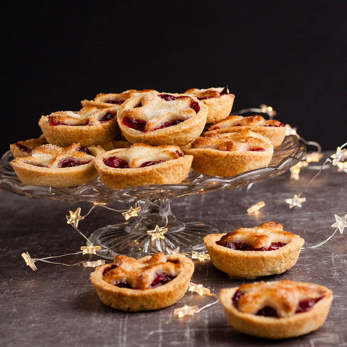 Cranberry and marzipan pies on a cake stand.