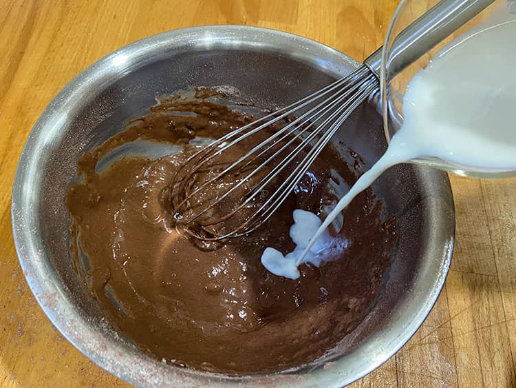 Adding remaining milk to the batter.
