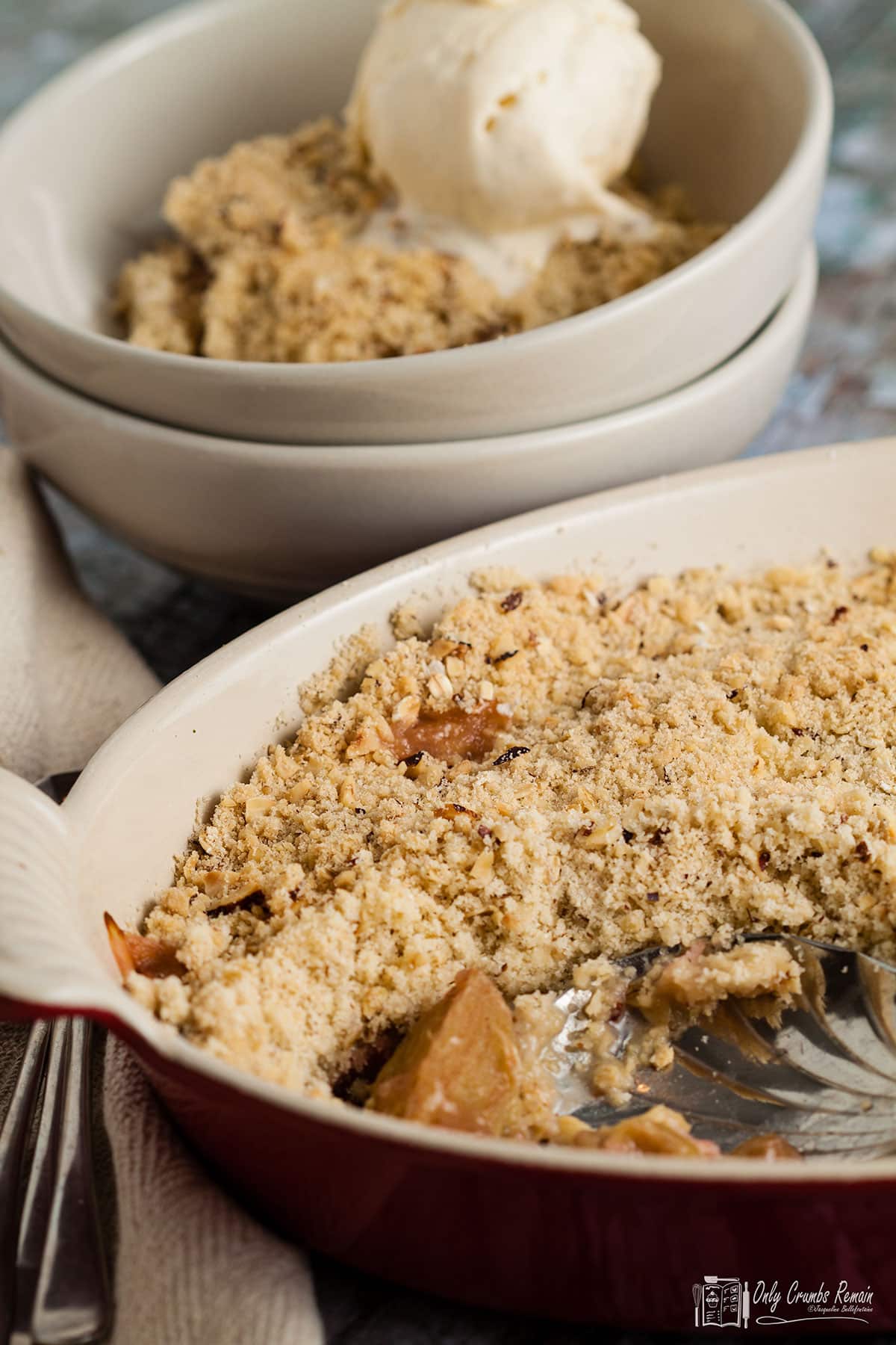 serving dish of crumble with portion taken out  and in a bowl behind.