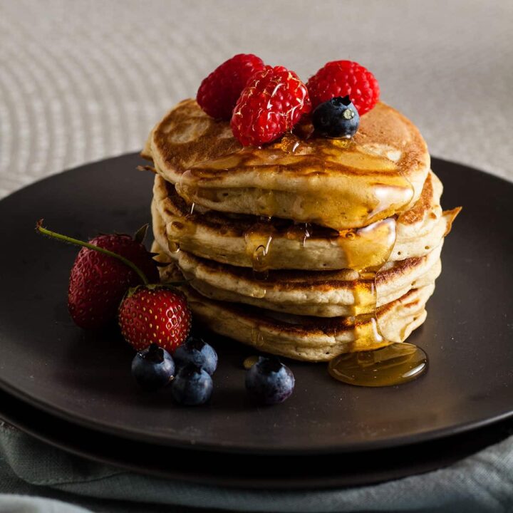 stack fo sourdough pancakes with fruit on top.