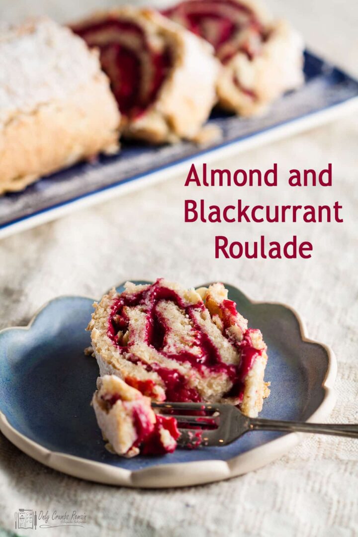 slice of almond roulade on plate with piece removed with fork.