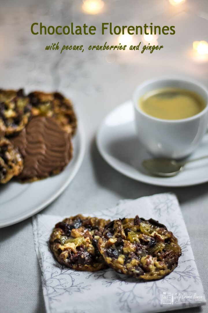 chocolate florentines on a serving plate with a cup of coffee and two biscuits on a napkin.