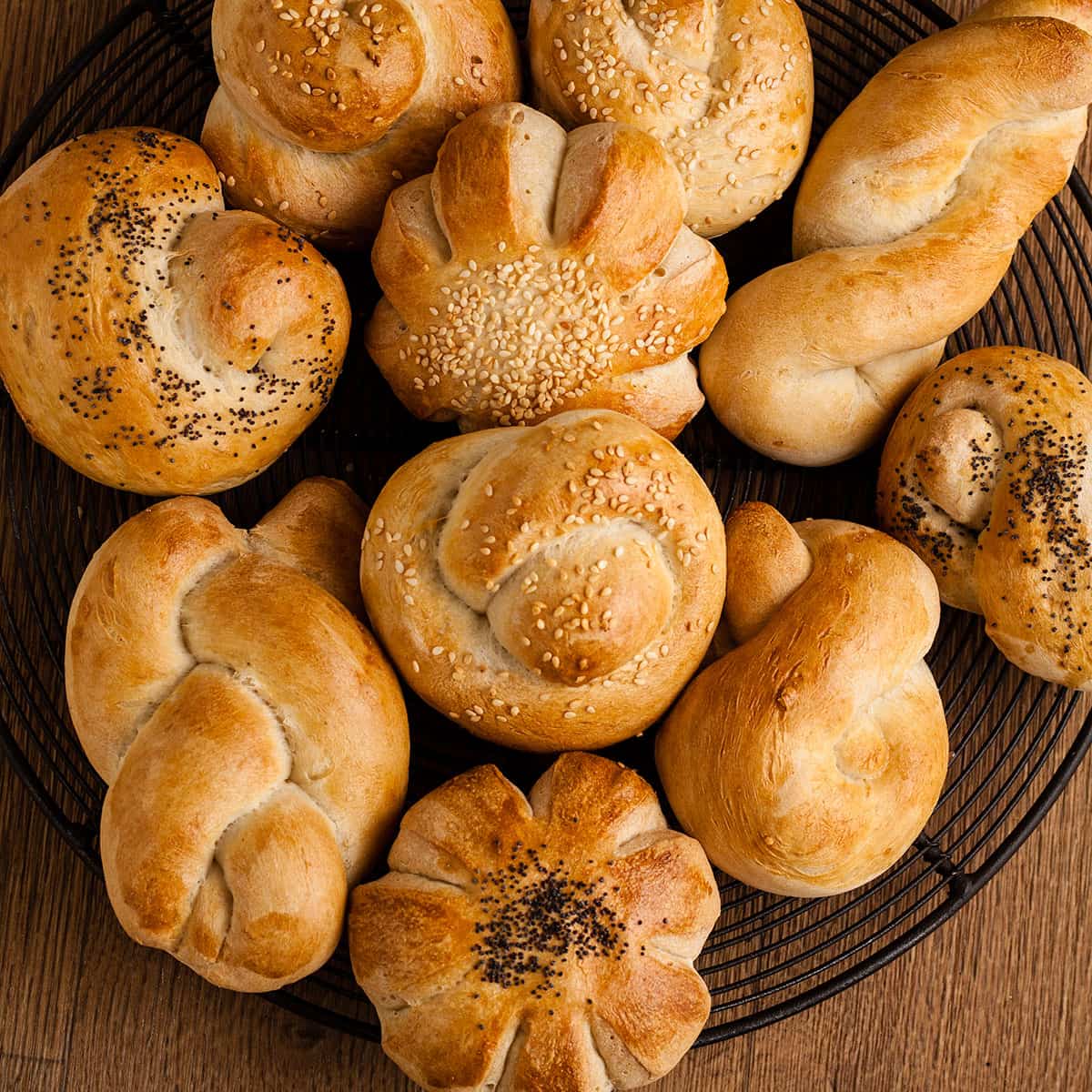 selection of fancy dinner rolls on a wire plate.