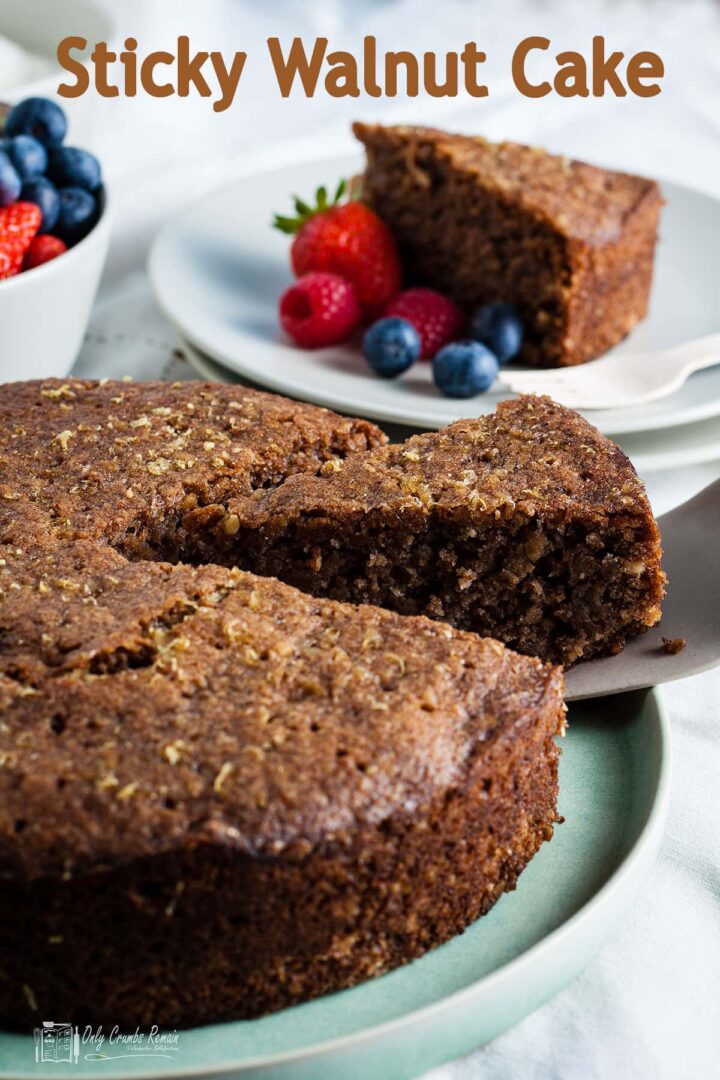 sticky walnut cake with slice being removed and text overlay for pinterest.
