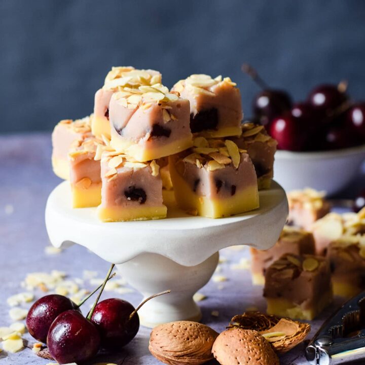 cherry and almond fudge on a mini cake stand with ingredients around the base