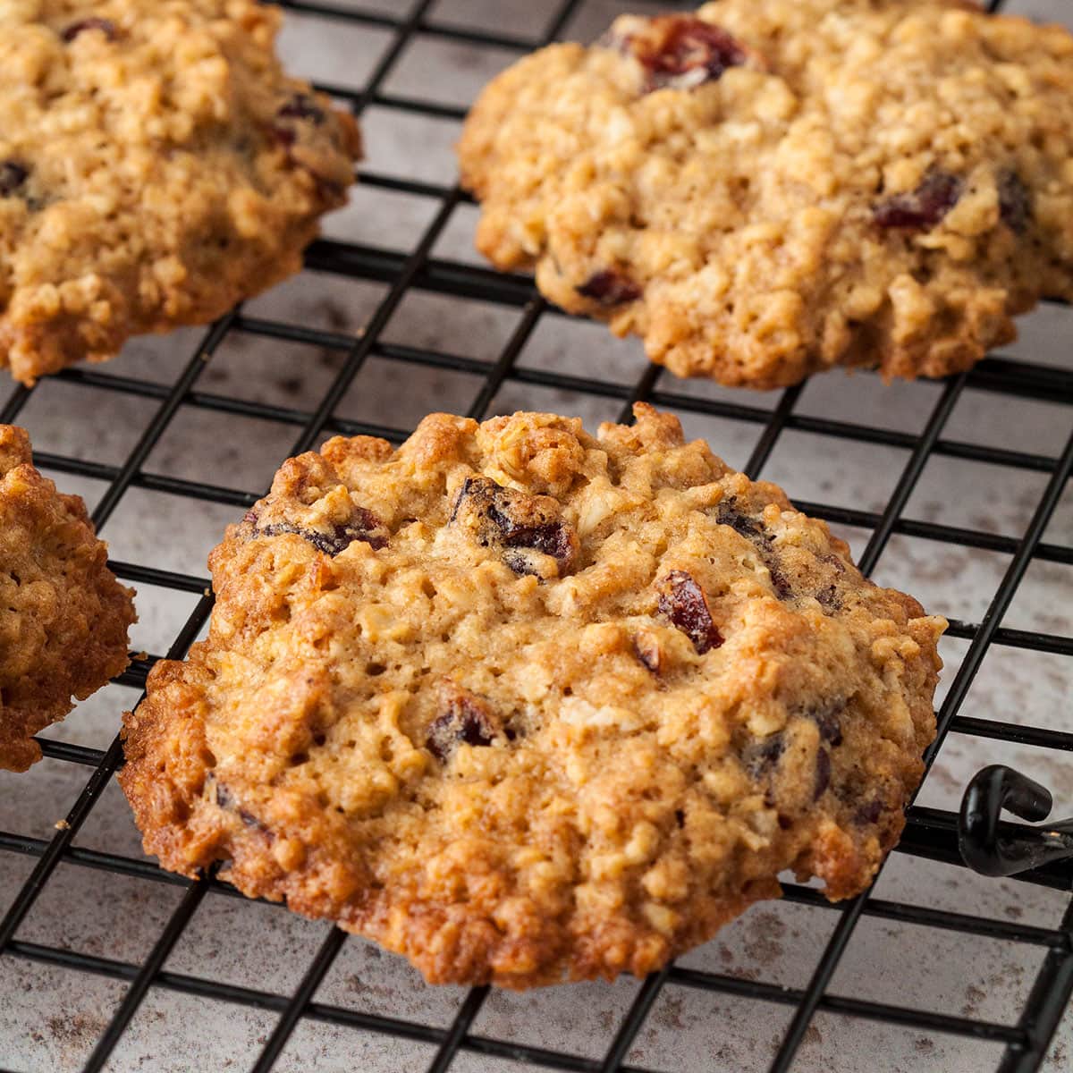 close up of cranberry and oat cookies on a cooling rack.