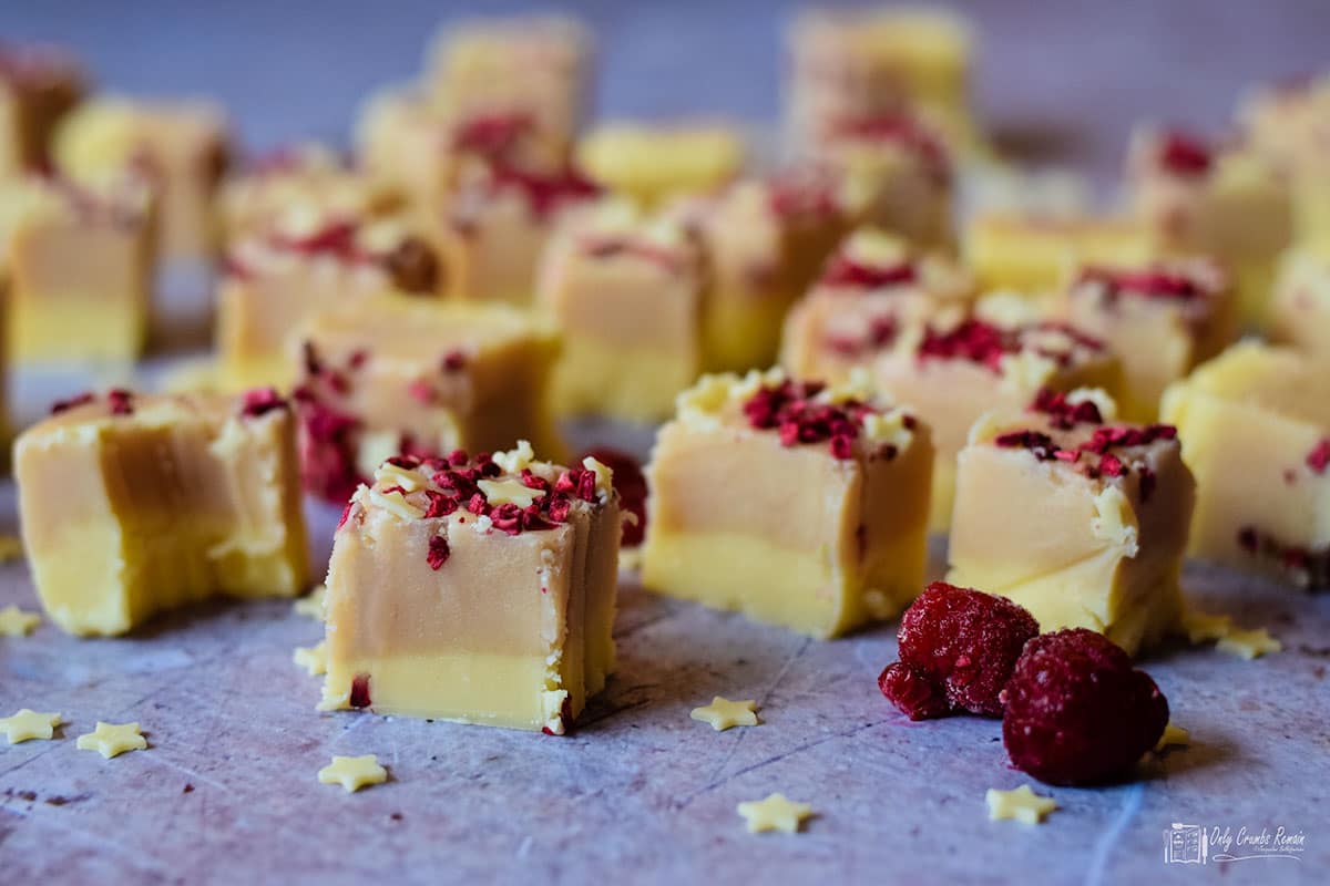 raspberry and white chocolate fudge cut into squares. showing the two layers of the fudge,