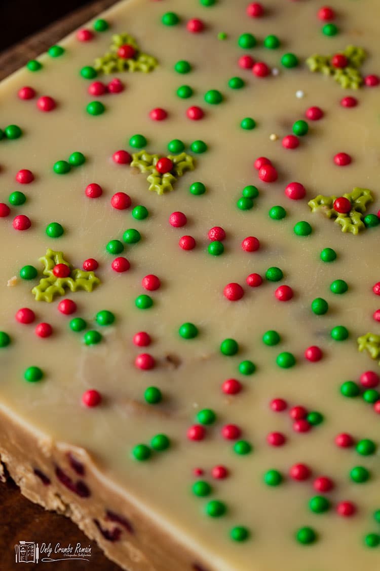 whole slab of Christmas fudge sprinkled with red and gree sugar balls and sugar holly sprinkles..
