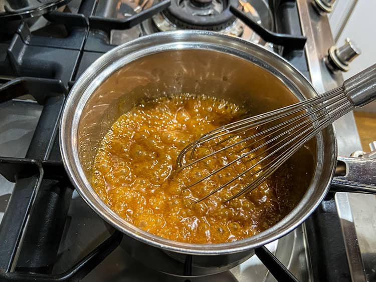 caramel sauce in pan with whisk.
