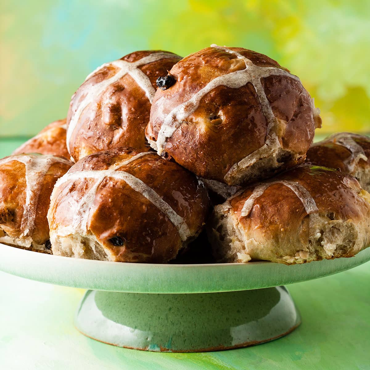 apple and sultana hot cross buns on a cake stand.