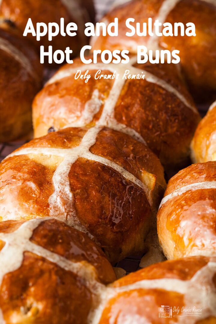 lines of apple and sultana hot cross buns on a baking tray.