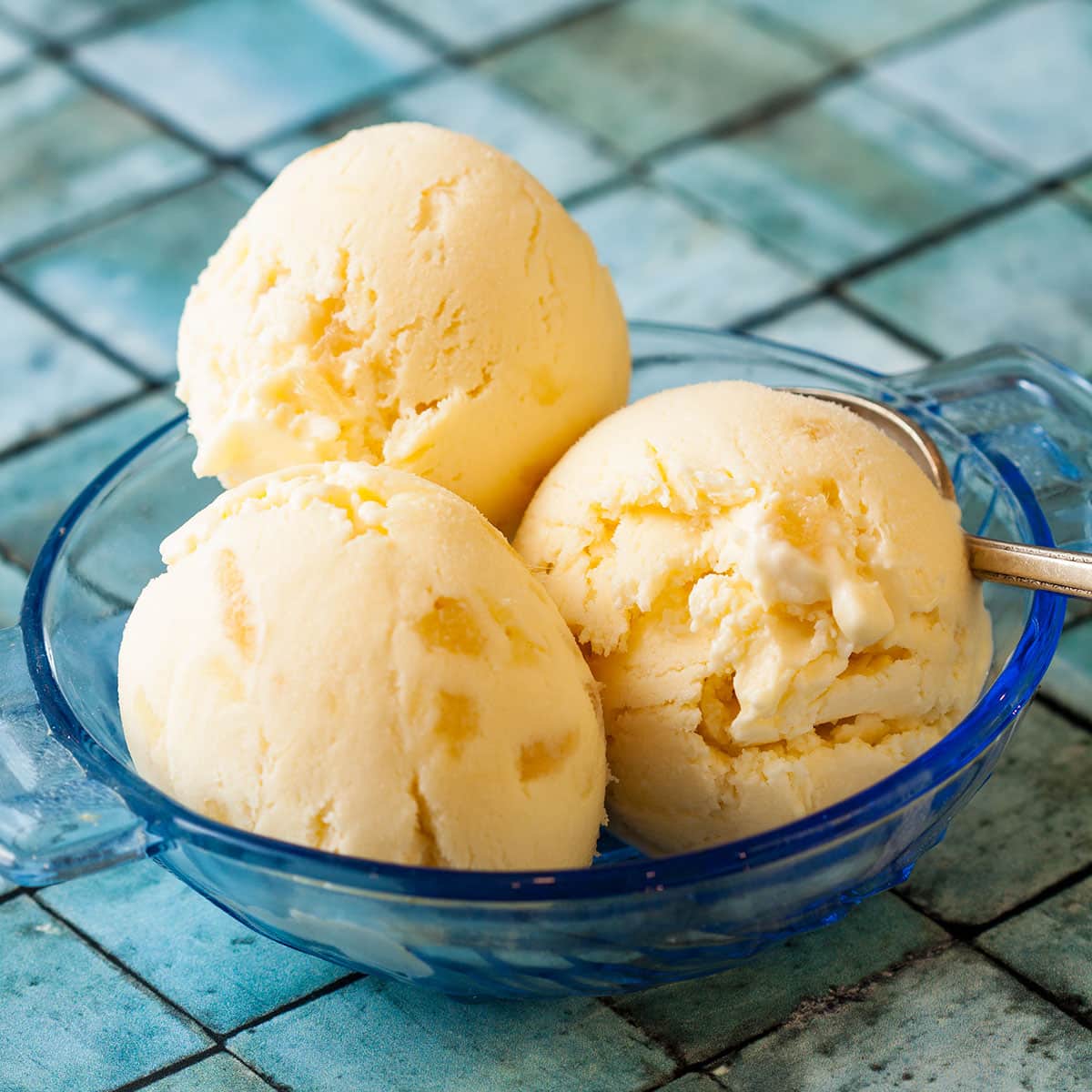 3 balls of stem ginger ice cream in a blue glass bowl.