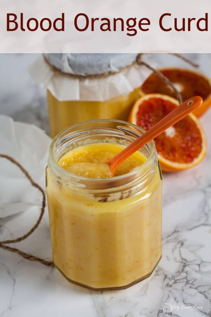 open jar of blood orange curd with closed jar behind.