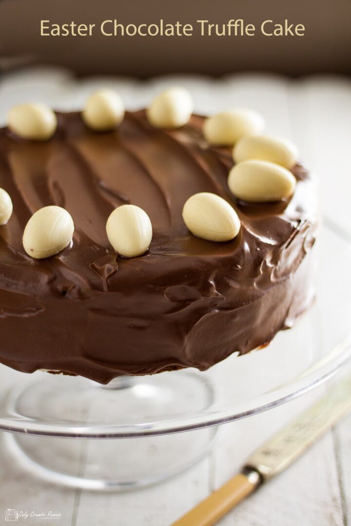 Easter chocolate truffle cake on stand with cake knife on table.