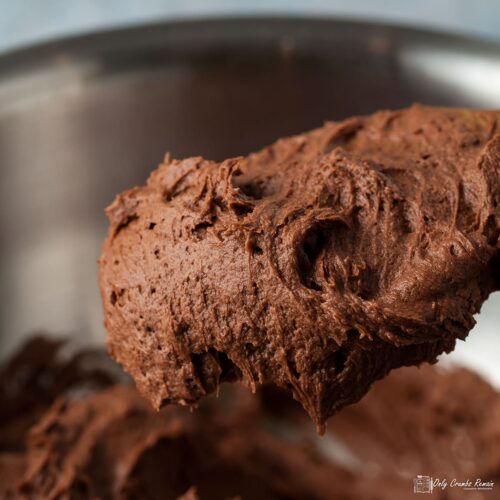 easy chocolate buttercream icing on a spoon held over a bowl.