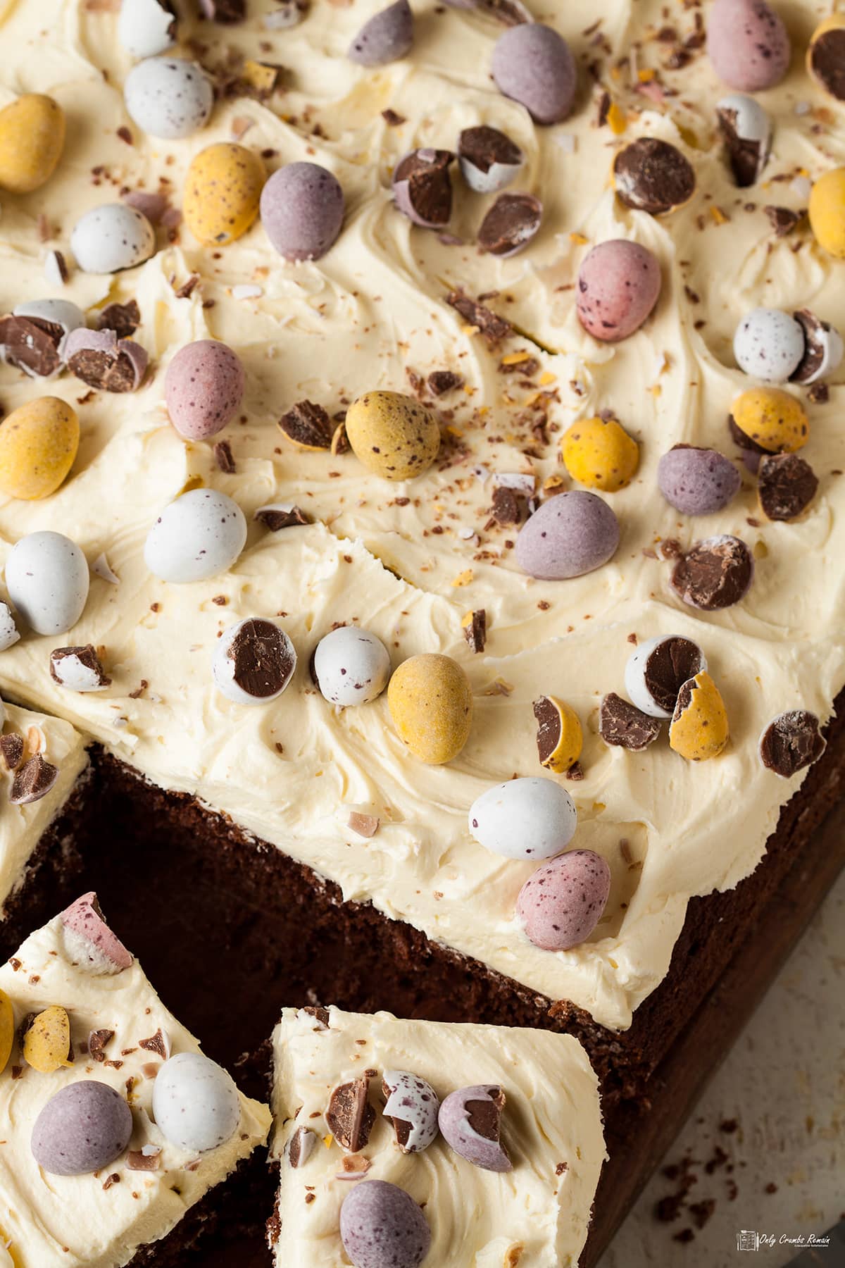 easy ch0colate easter traybake on board with two pieces cut