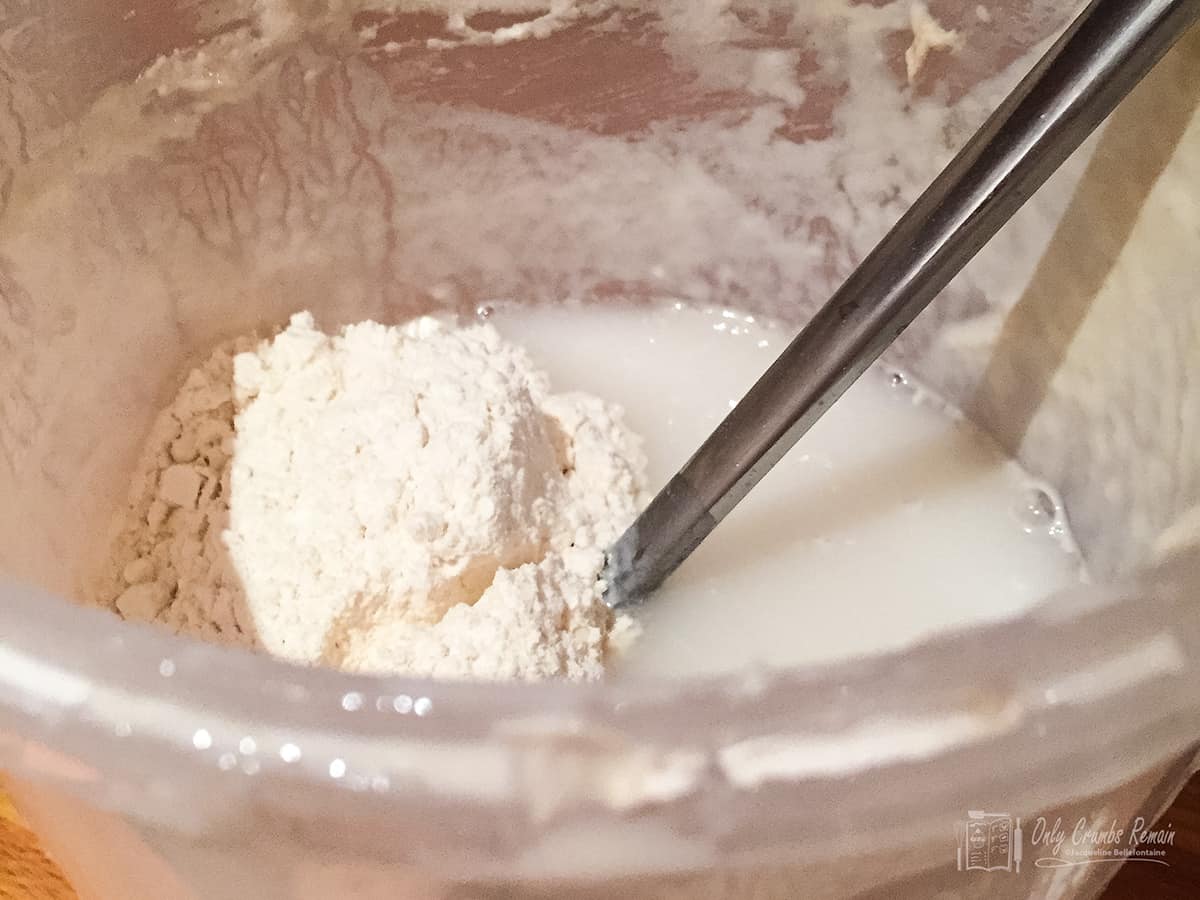 adding flour and water to sourdough to make as sourdough starter .